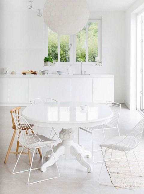 All white dining room with mismatched chairs