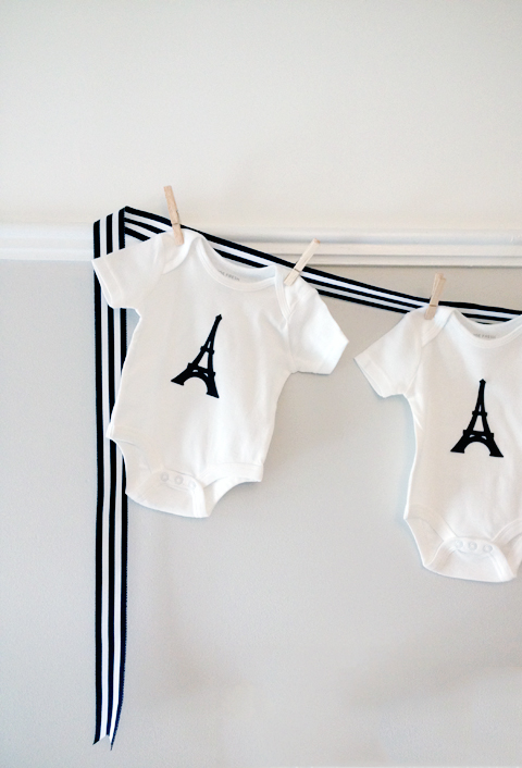 Baby shower decor: adorable onesies pinned to grossgain ribbon