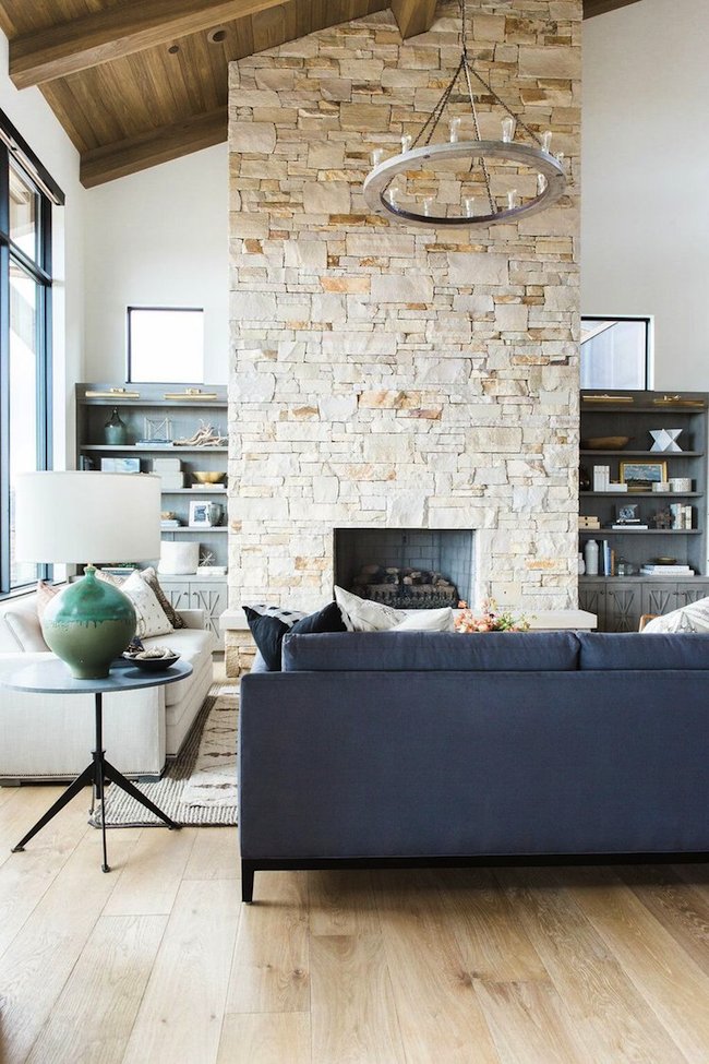 4Great+room+with+dramatic+stone+fireplace,+layered+rugs,+and+neutral+color+scheme